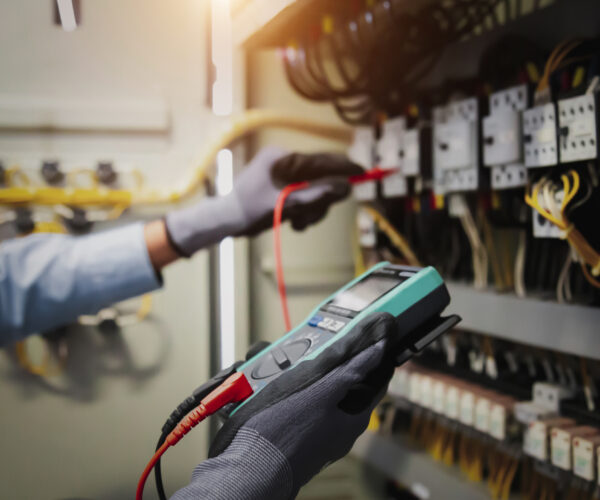 Electricity and electrical maintenance service, Engineer hand holding AC multimeter checking electric current voltage at circuit breaker terminal and cable wiring main power distribution board. Electricity and electrical maintenance service, Engineer hand holding AC multimeter checking electric current voltage at circuit breaker terminal and cable wiring main power distribution board.